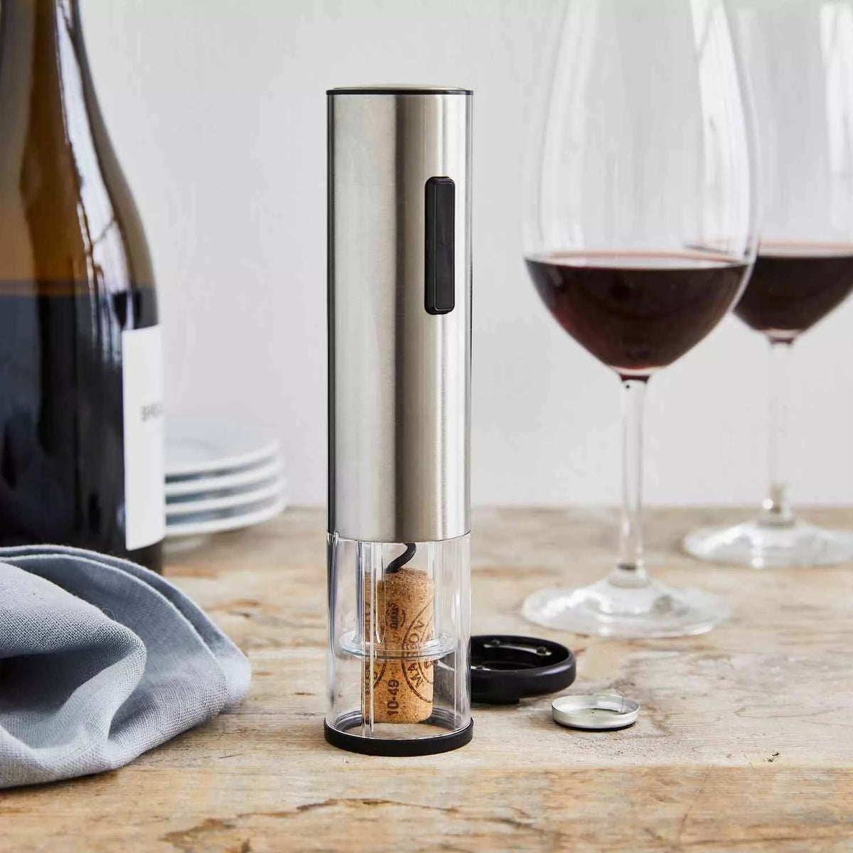 Electric wine opener with removed cork on a wooden table